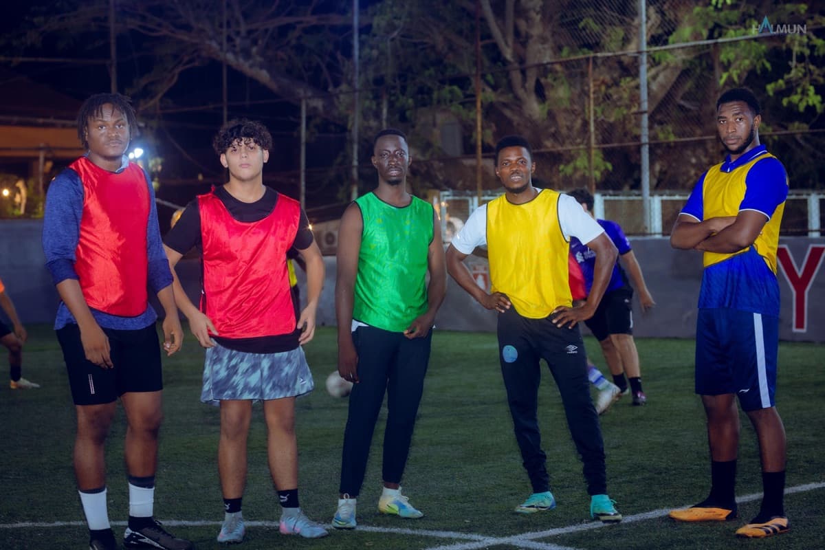 Five players lined up in red, green, yellow and blue training bibs.