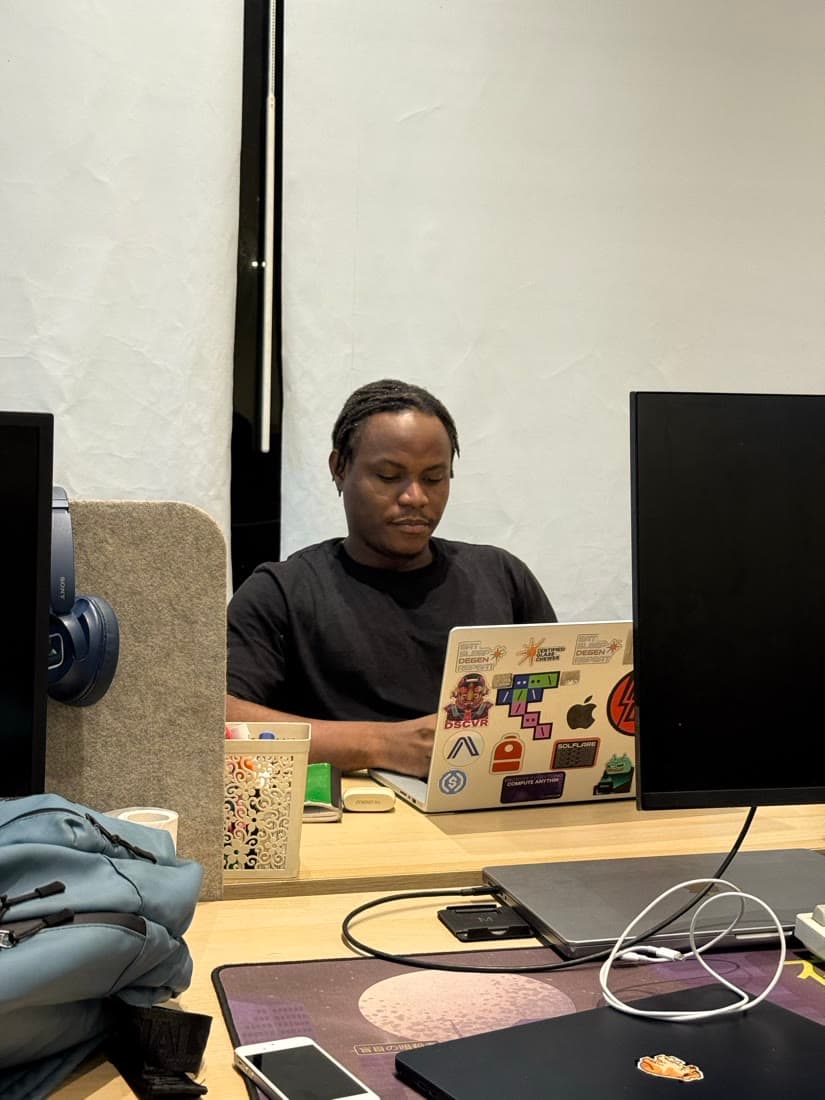 Locked in at a desk, sticker-covered laptop open.