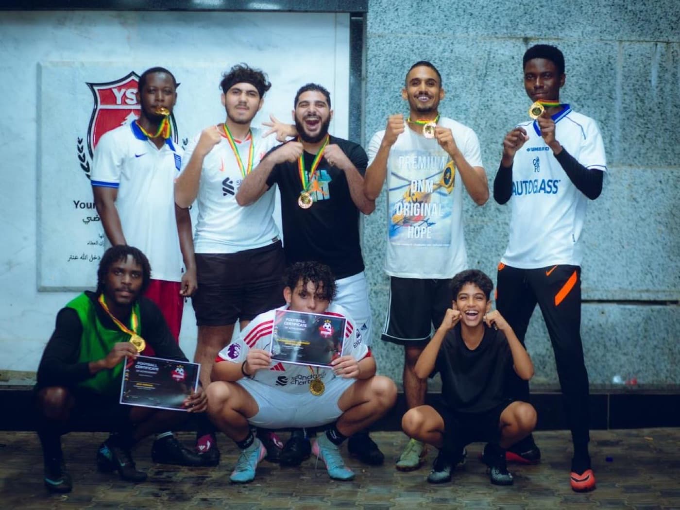 The team celebrating with medals and certificates.