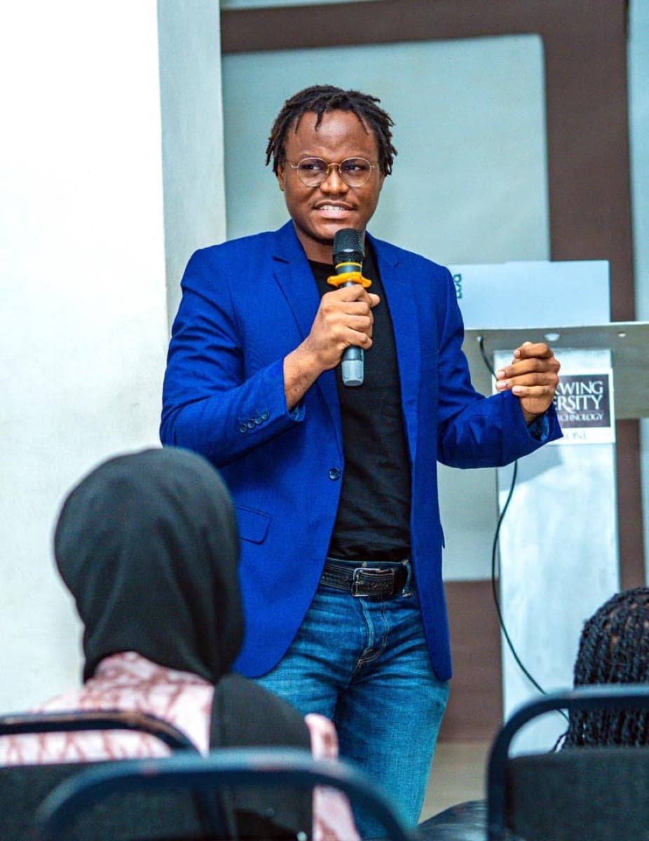 Speaking with a mic at Limkokwing, blue blazer on.