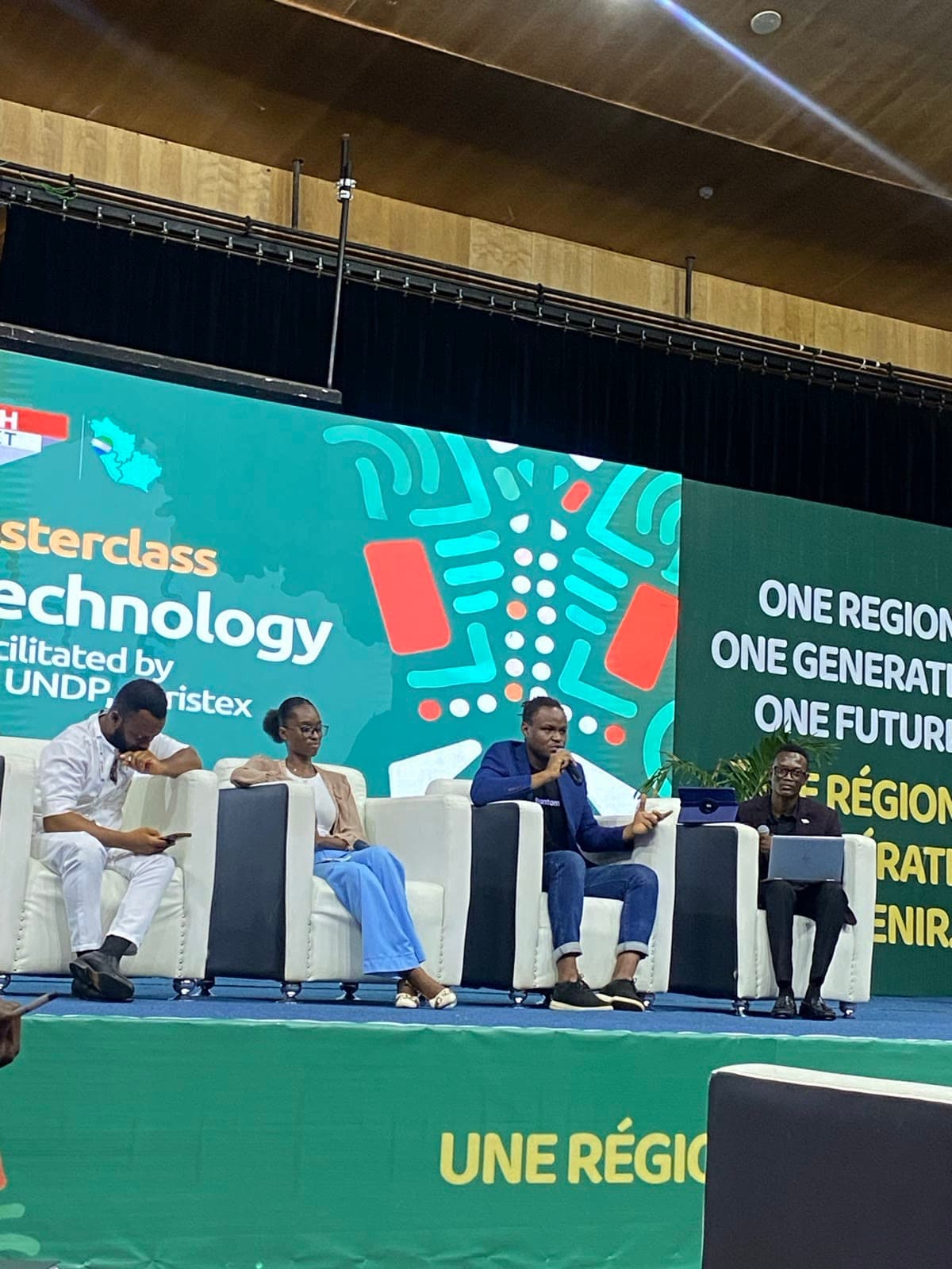 On the masterclass panel, mic up, mid-answer.