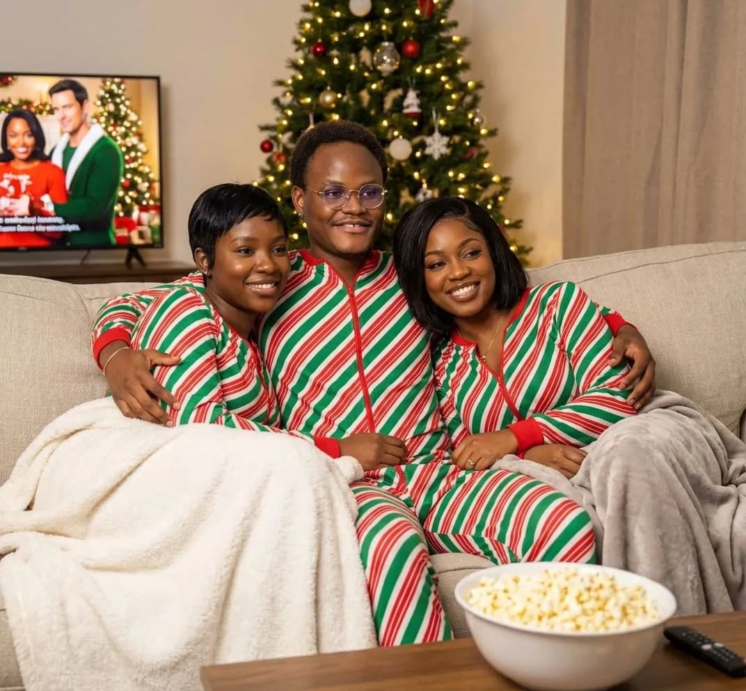 Trio in candy-cane striped onesies on the couch